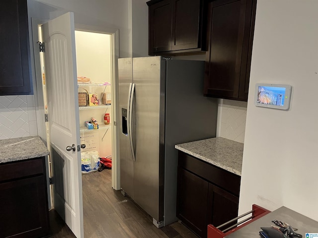 kitchen featuring dark wood-style floors, light stone counters, decorative backsplash, and stainless steel fridge with ice dispenser