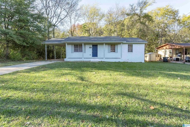 single story home with a storage unit, a front lawn, and a carport