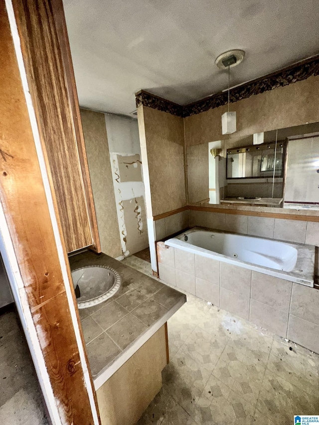 bathroom with vanity and tiled tub