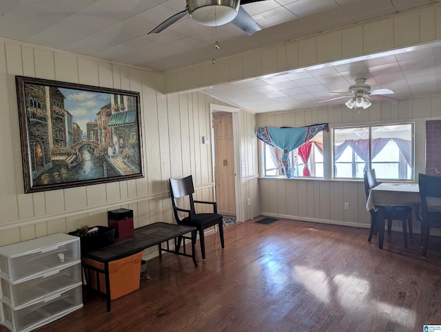 living area with wood-type flooring and ceiling fan