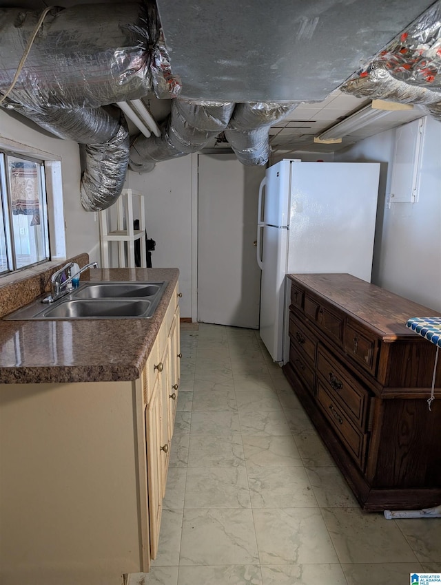 kitchen with white refrigerator, sink, and cream cabinets
