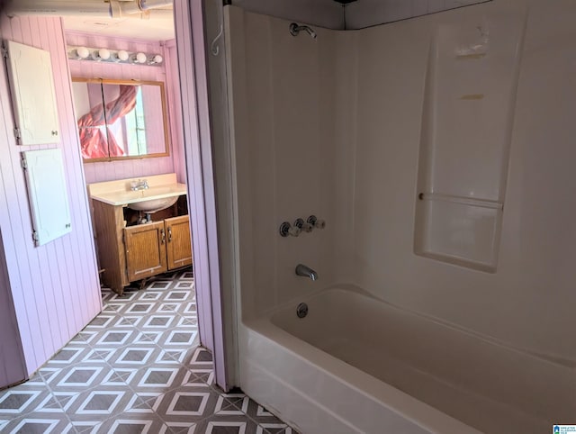 bathroom featuring vanity, wooden walls, and shower / bathing tub combination