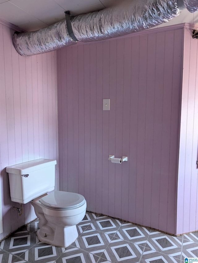bathroom with toilet and wooden walls