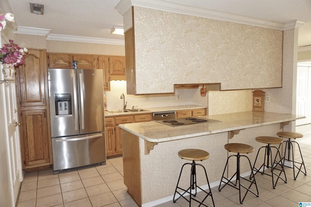 kitchen with appliances with stainless steel finishes, a kitchen breakfast bar, ornamental molding, sink, and kitchen peninsula