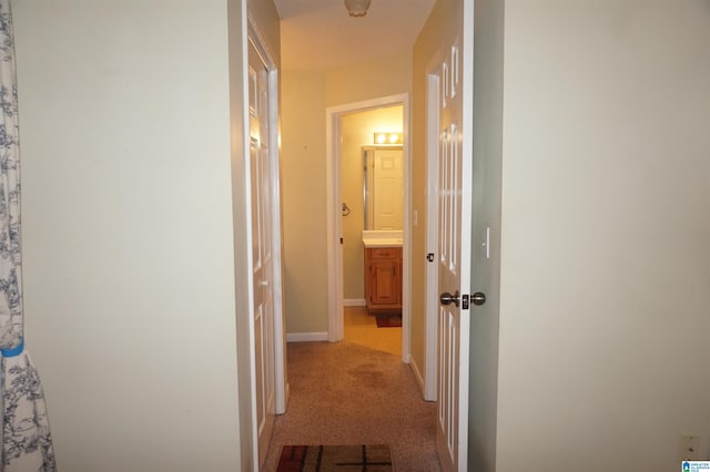hallway featuring light colored carpet