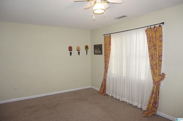 empty room with a textured ceiling, carpet flooring, and ceiling fan