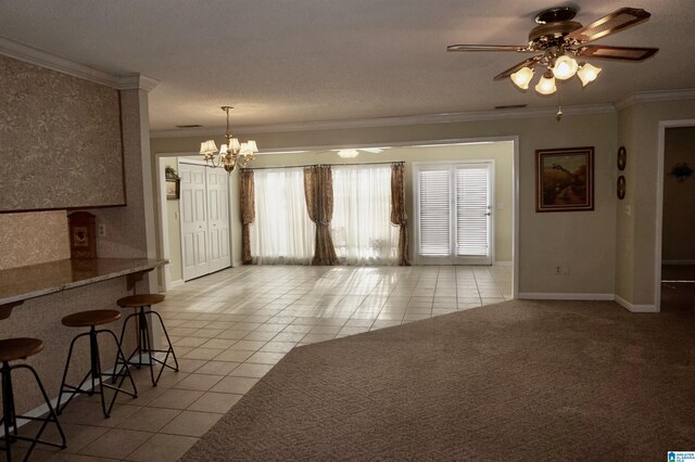 unfurnished living room featuring crown molding, light tile patterned flooring, and ceiling fan with notable chandelier