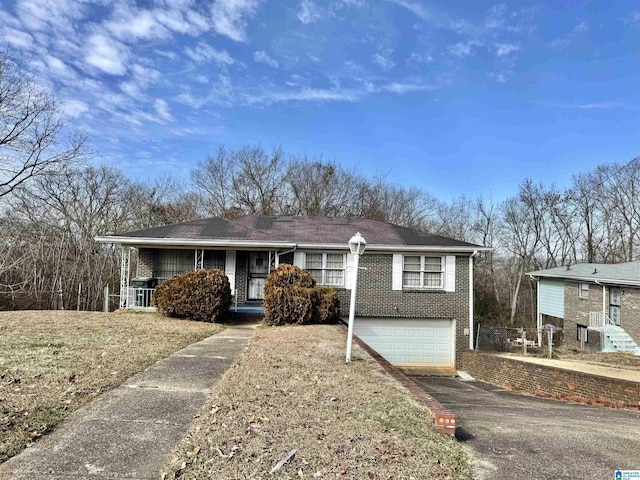 view of front facade with covered porch, a front yard, and a garage