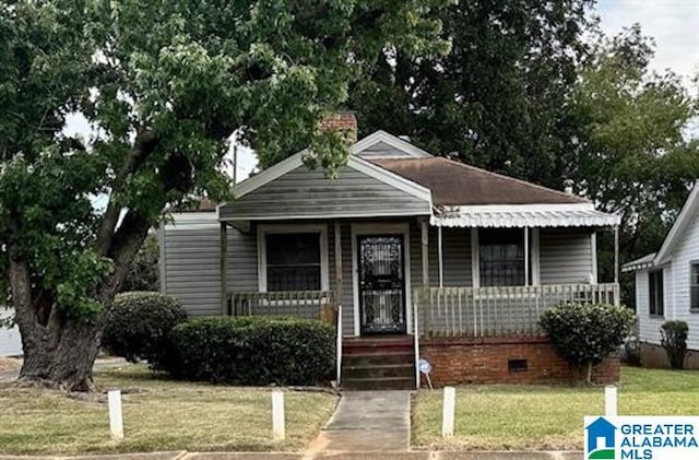 bungalow-style house featuring covered porch and a front yard