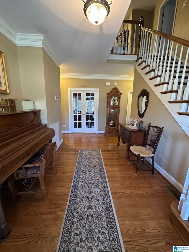 foyer with ornamental molding, french doors, stairway, and wood finished floors