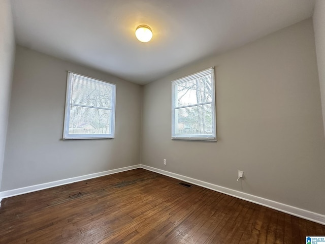 empty room with dark hardwood / wood-style flooring