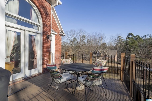 wooden terrace featuring french doors and outdoor dining area