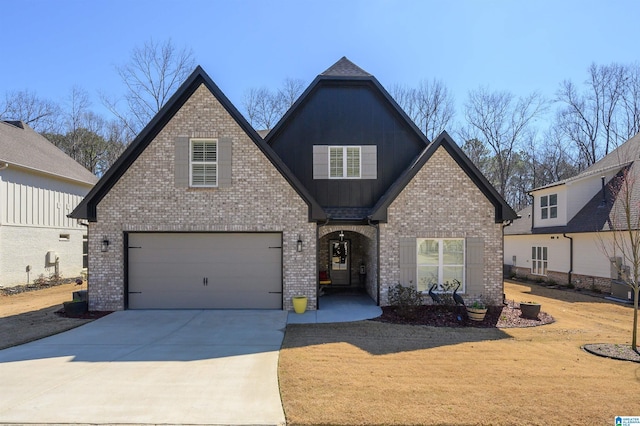 view of front of house with a garage, brick siding, driveway, and board and batten siding