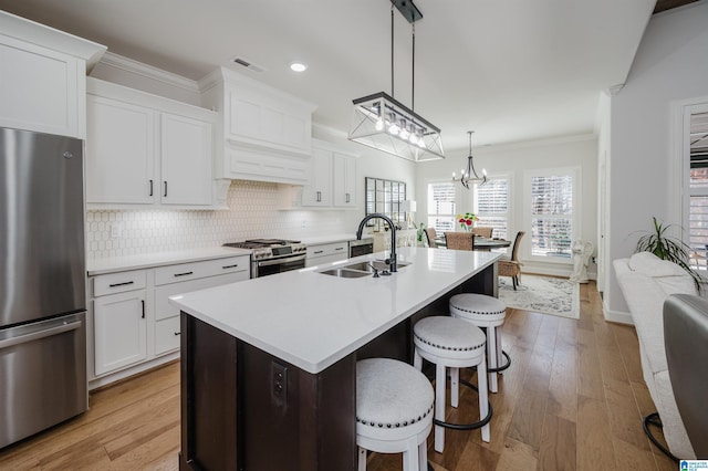 kitchen featuring stainless steel appliances, a sink, visible vents, decorative backsplash, and crown molding