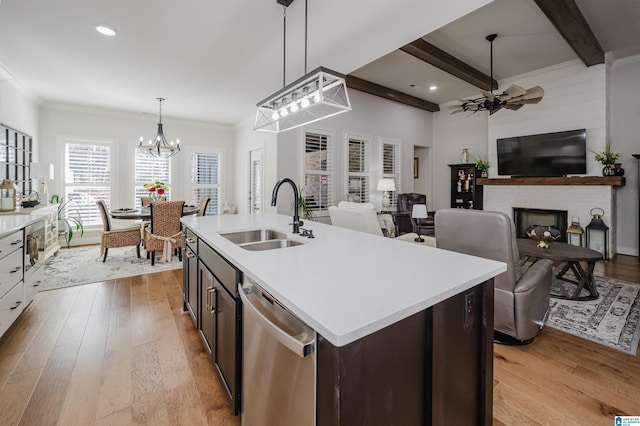 kitchen with stainless steel dishwasher, beamed ceiling, a sink, and light wood-style flooring