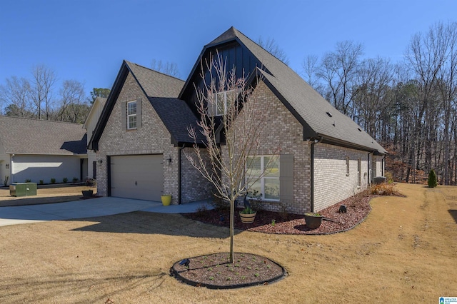 view of home's exterior with driveway, brick siding, roof with shingles, and a balcony