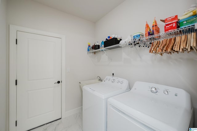 washroom with marble finish floor, washing machine and clothes dryer, a sink, laundry area, and baseboards