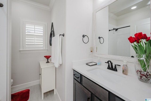 full bath with baseboards, a shower, toilet, crown molding, and vanity