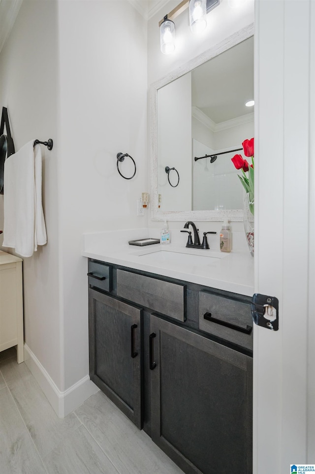 full bathroom featuring ornamental molding, vanity, and baseboards