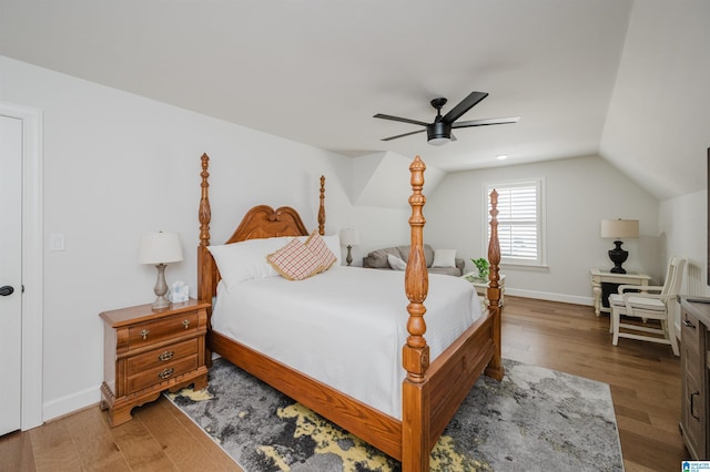 bedroom with vaulted ceiling, ceiling fan, wood finished floors, and baseboards