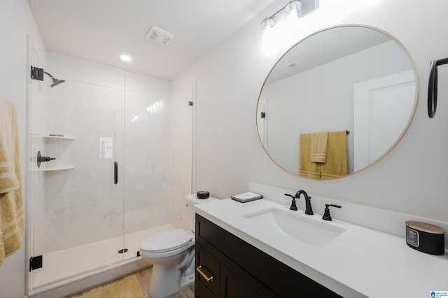 bathroom featuring toilet, vanity, a marble finish shower, and visible vents