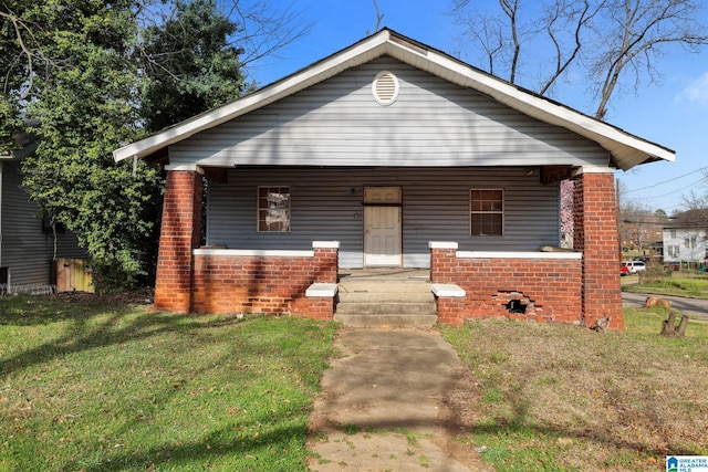 bungalow-style home with covered porch and a front yard