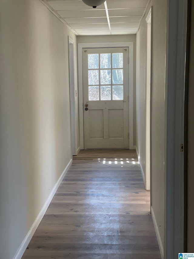doorway with baseboards and wood finished floors