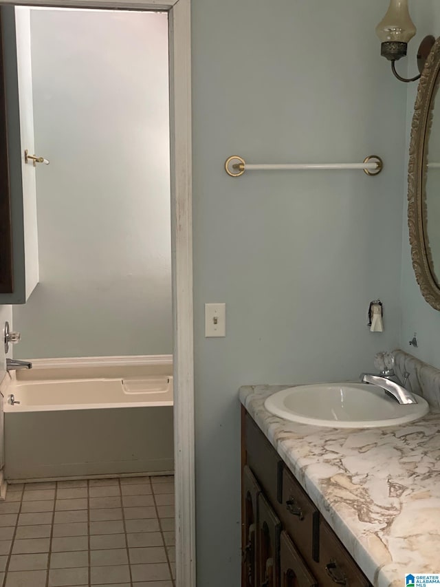 full bath featuring vanity, a bath, and tile patterned flooring