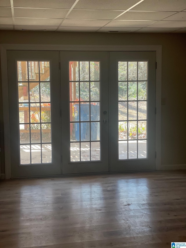 doorway featuring wood finished floors, french doors, and a paneled ceiling