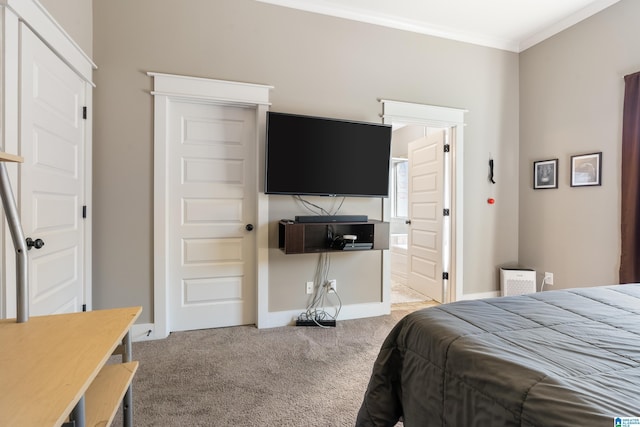 bedroom with carpet floors, ensuite bath, baseboards, and ornamental molding