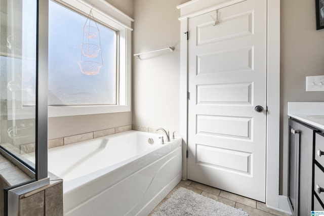 full bathroom featuring vanity, a bath, and tile patterned floors