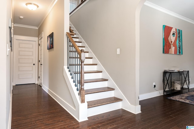 staircase featuring baseboards, ornamental molding, arched walkways, and wood finished floors