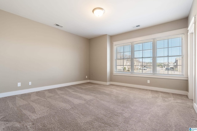 carpeted empty room with baseboards and visible vents