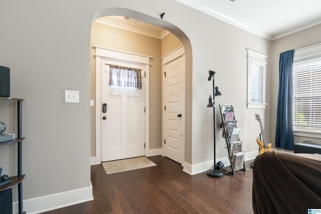 entrance foyer with baseboards, arched walkways, dark wood finished floors, and ornamental molding