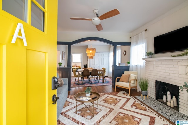 entrance foyer featuring hardwood / wood-style flooring, plenty of natural light, a brick fireplace, and ceiling fan