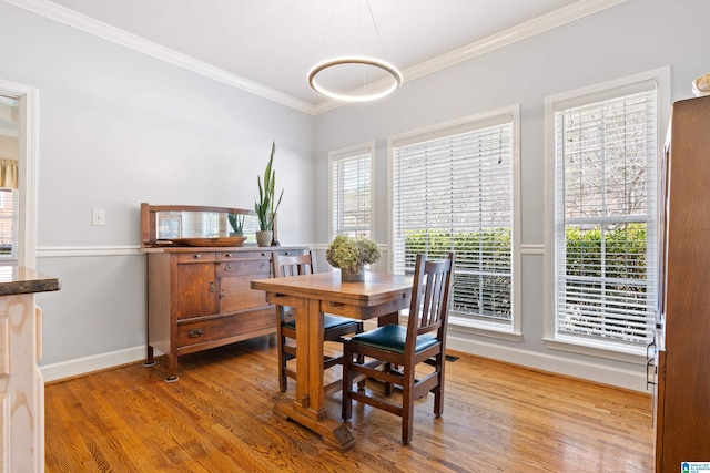 dining area featuring ornamental molding, wood finished floors, and baseboards