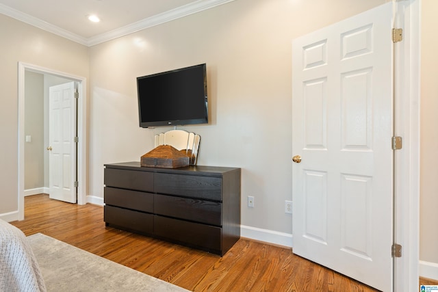 bedroom with ornamental molding, recessed lighting, wood finished floors, and baseboards