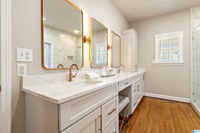 full bathroom with plenty of natural light, visible vents, a sink, and a tile shower