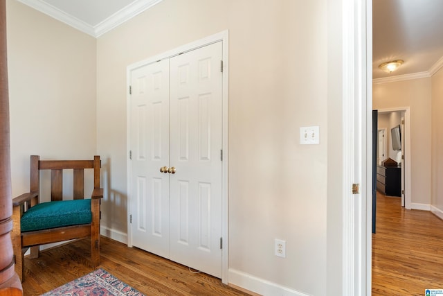 living area featuring baseboards, crown molding, and wood finished floors