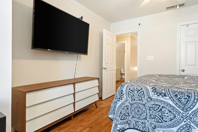 bedroom featuring ornamental molding, visible vents, and light wood finished floors