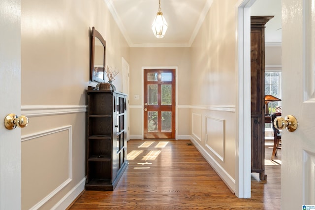 foyer entrance with a healthy amount of sunlight, baseboards, ornamental molding, and wood finished floors