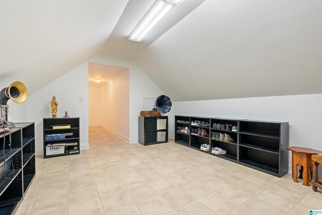 additional living space with lofted ceiling, baseboards, and tile patterned floors