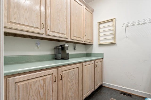 interior space with light countertops, visible vents, baseboards, and light brown cabinetry