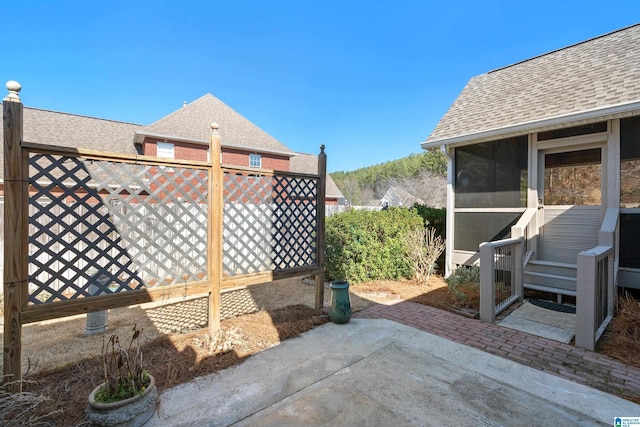 view of patio / terrace featuring a sunroom and fence