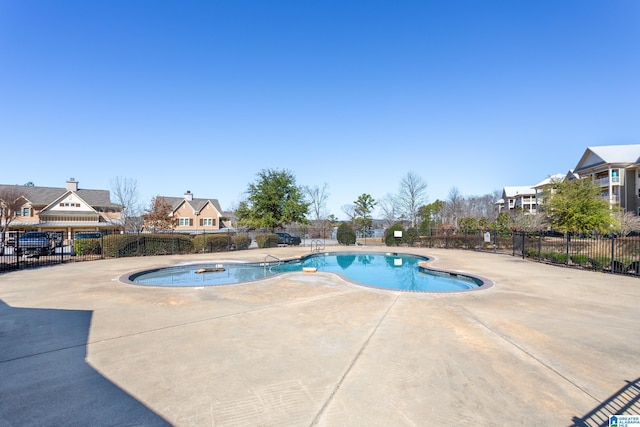 pool with a patio area and fence