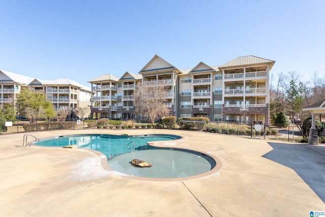 pool with a patio and fence