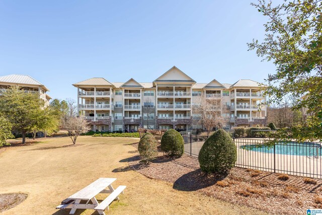 view of property with a community pool and fence