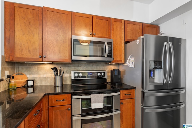 kitchen featuring dark stone counters, appliances with stainless steel finishes, brown cabinets, and decorative backsplash