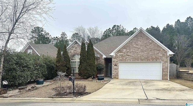 view of front of home featuring a garage, concrete driveway, and brick siding