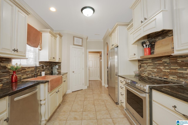 kitchen with a sink, stainless steel appliances, crown molding, backsplash, and light tile patterned flooring